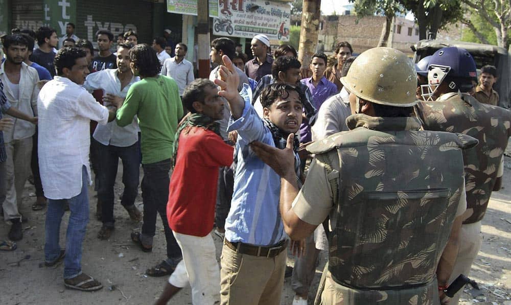 People argue with Indian policemen during curfew hours following riots and clashes between two communities in Muzaffarnagar, Uttar Pradesh.