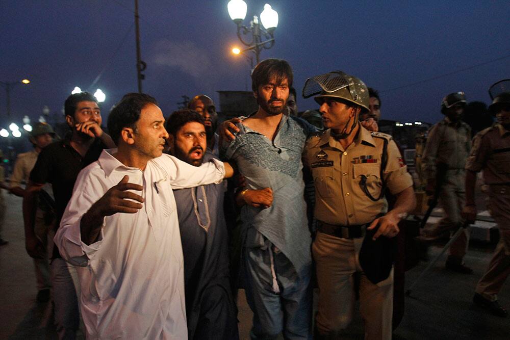 A police officer detains Kashmiri separatist leader Yasin Malik, center, during a protest after paramilitary troops fired on a civilian when he allegedly failed to stop the car he was driving at a police barricade in Srinagar.