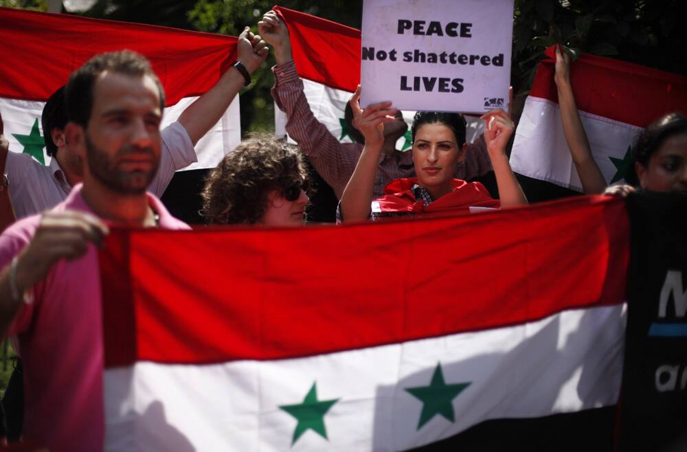 Syrians living in India hold a Syrian flag and participate in a protest march against a possible US-led attack on Syria, towards the US embassy in New Delhi.