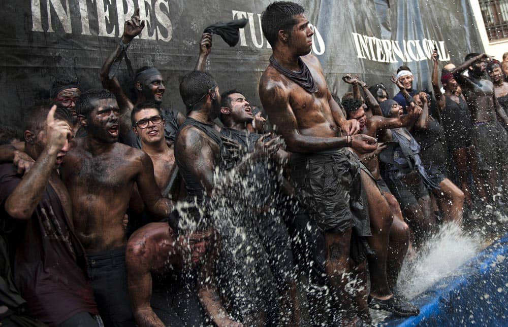 People painted with black grease take part at the traditional festivities of the Cascamorras festival, in the streets of Baza, Granada, Spain.