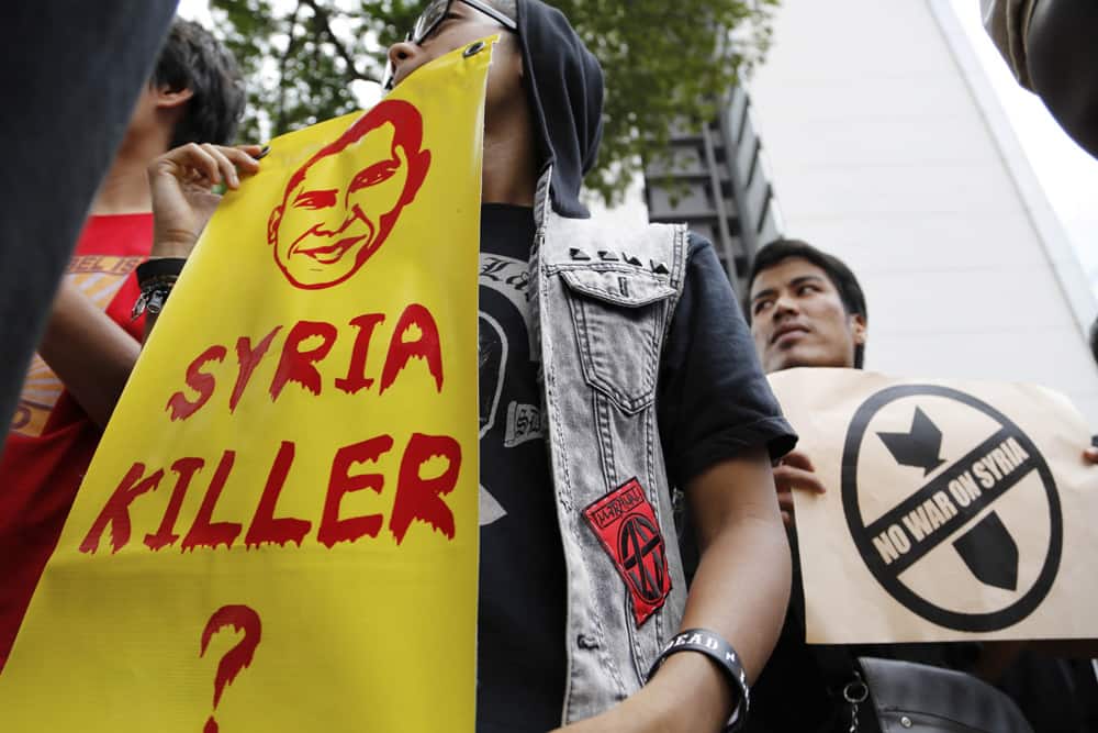Muslim demonstrators hold placards during a rally against the US intervention in Syria outside the US Embassy after the Friday prayer in Kuala Lumpur, Malaysia.