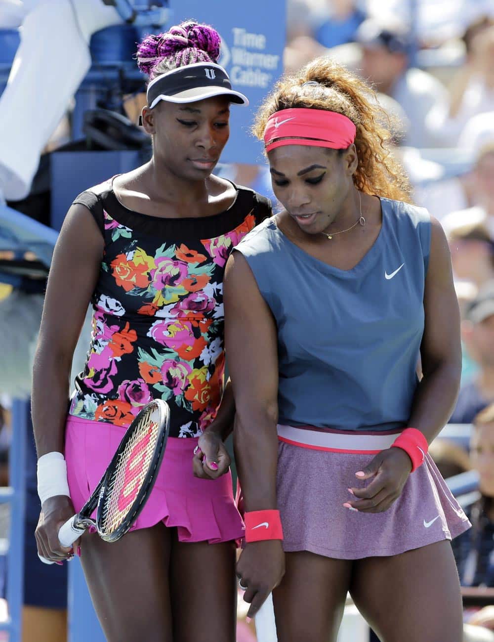 Venus Williams, left, and Serena Williams plan the next point against Sara Errani, of Italy, and Roberta Vinci, of Italy, during the women`s doubles quarterfinals of the 2013 US Open tennis tournament.