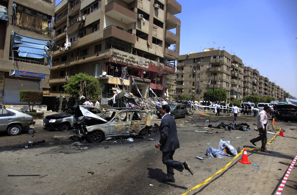 Egyptian security officers gather at the scene of a bomb attack targeting the convoy of Egypt`s Interior Minister Mohammed Ibrahim, in Nasr City, Cairo, Egypt.