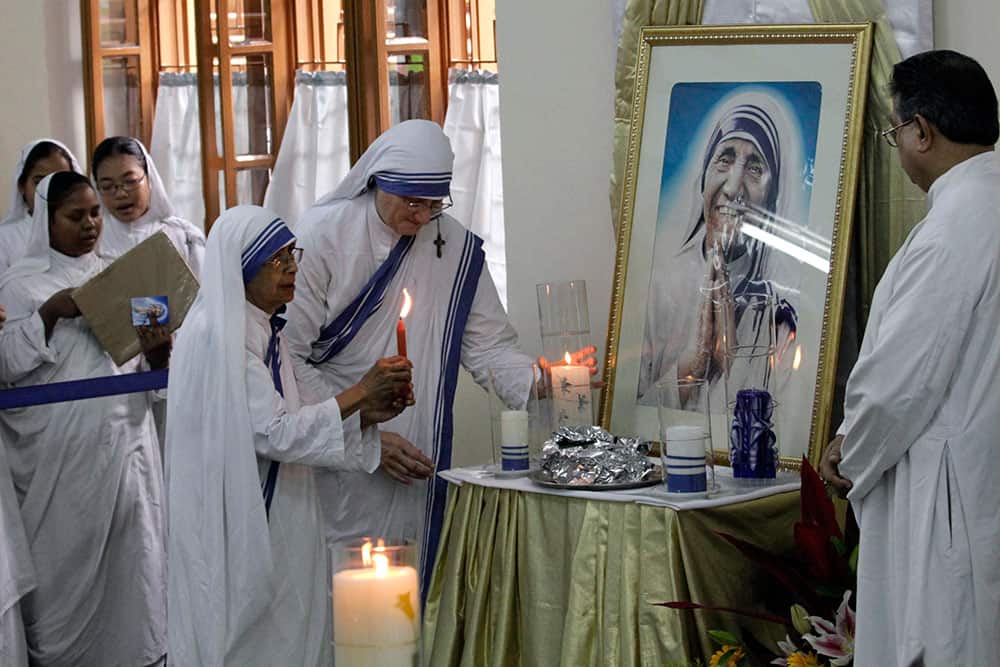Sister Mary Prema, superior general of the Missionaries of Charity, helps Sister Nirmala, former superior general to light the lamp at the tomb of the founder of the order, Mother Teresa on her death anniversary in Kolkata.