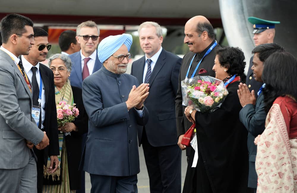 In this photograph provided by the G20 host broadcaster, Prime Minister Manmohan Singh greets unidentified members of the Indian delegation as he arrives in St. Petersburg, Russia.
