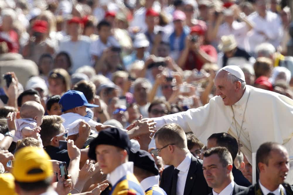 Pope Francis greets faithful as he arrives for his weekly general audience in St. Peter`s square at the Vatican.