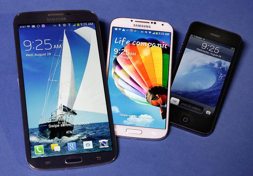 The Samsung Galaxy Mega, left, Samsung Galaxy S4, center, and Apple iPhone 5 are shown in this photo, in New York.