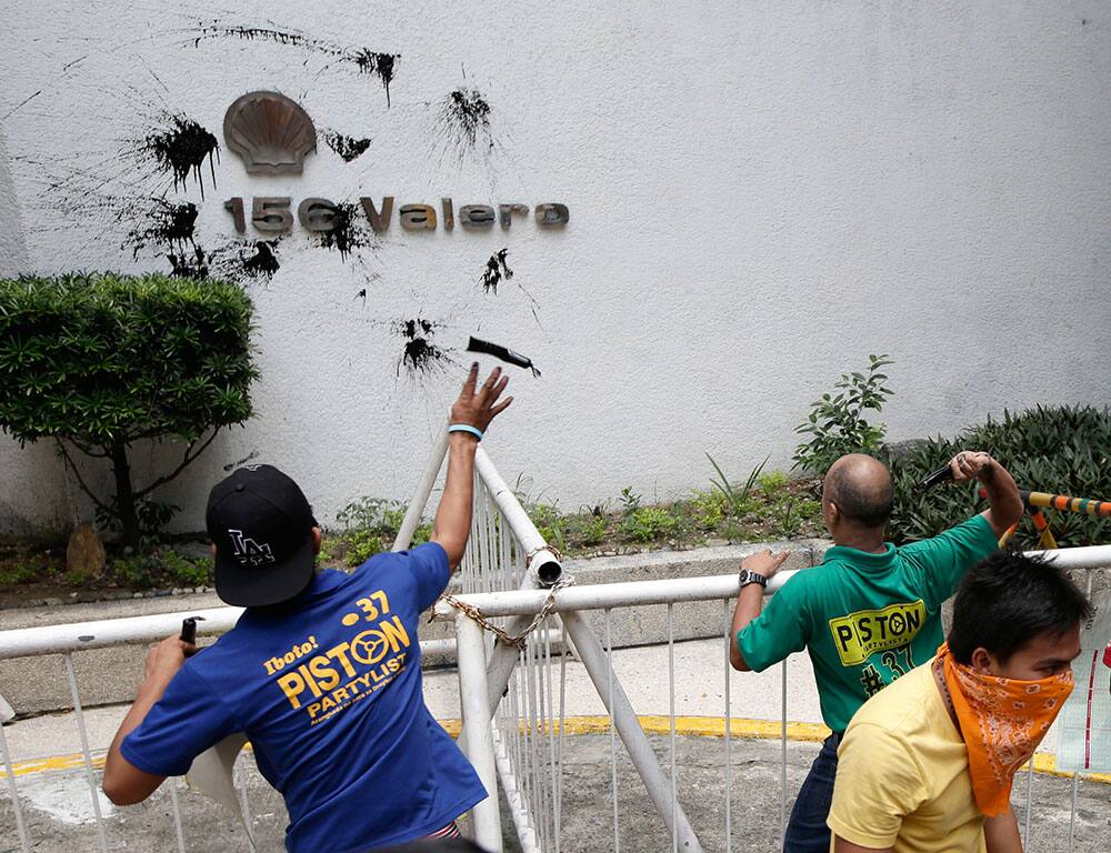 Protesters throw used oil at the seal of Shell Oil Company, one of the so-called Big 3 oil firms in the country, to protest a new round of gasoline and other oil products at the financial district of Makati city, east of Manila, Philippines.