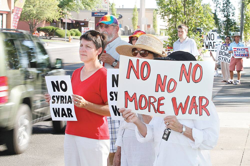 Nine people gather to demonstrate in front of Richland City Hall in Richland, Wash., in opposition to proposed US military action in Syria. Jim Stoffels, chairman of World Citizens for Peace, organized the rally, which is expected every day from 4 to 5 p.m. until Congress reconvenes Sept. 9.