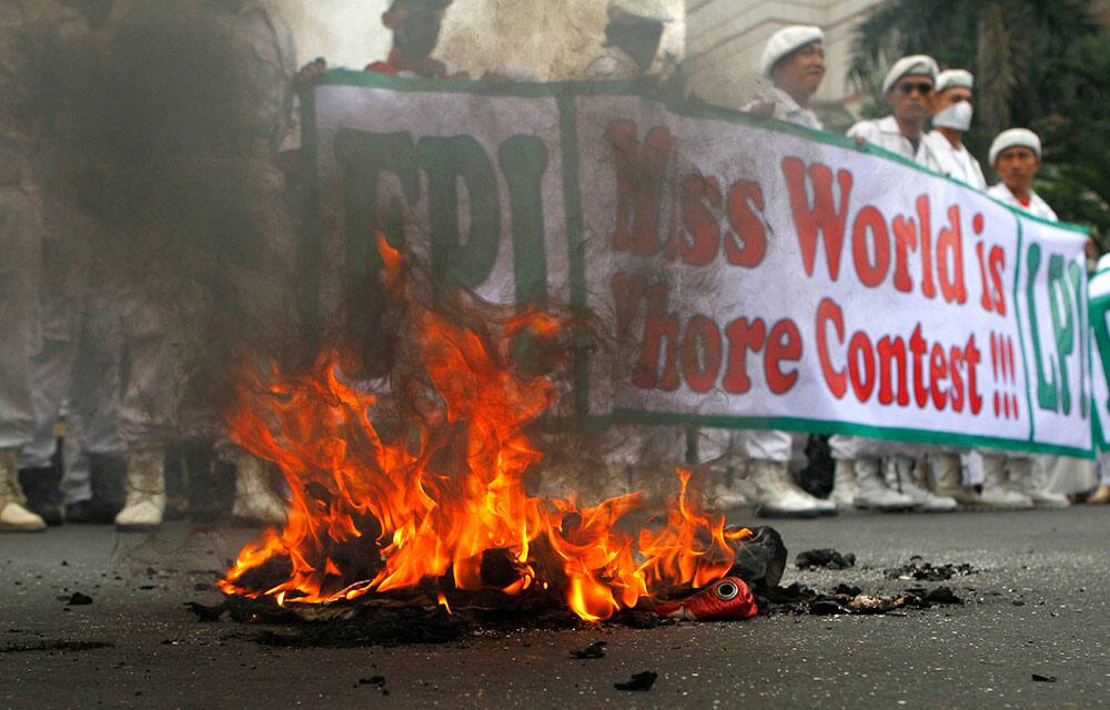 A banner is seen burned during a protest calling for the cancellation of Miss World pageant in Jakarta, Indonesia.