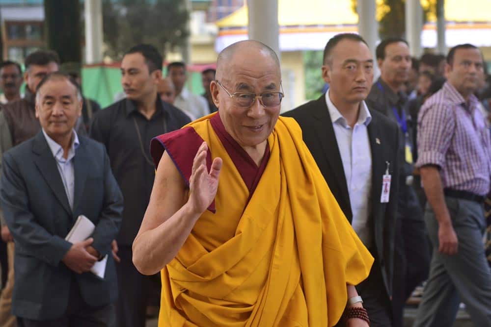 Tibetan spiritual leader the Dalai Lama, center, gestures as he arrives to give a religious talk at the Tsuglakhang temple in Dharmsala.