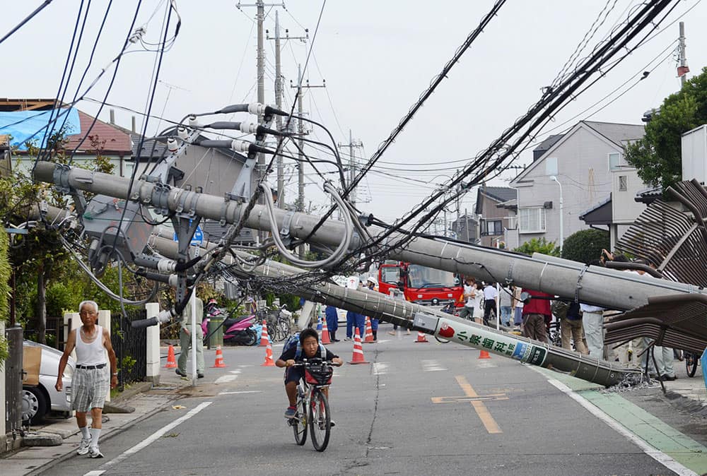 Utility poles fall over a road after a tornado in Koshigaya city, Saitama Prefecture, north of Tokyo. Tornadoes tore through eastern Japan on Monday, leaving dozens of people injured, at least one seriously, and destroying some buildings.