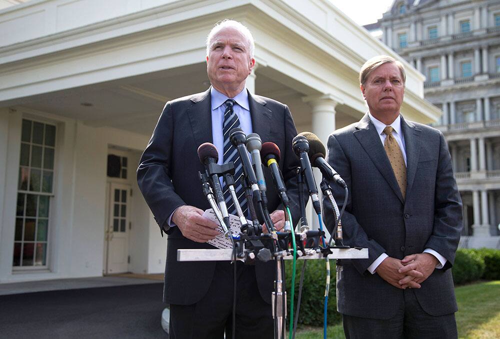 Sen. John McCain, R-Ariz., left, accompanied by Sen. Lindsey Graham, R-S.C., speaks with reporters outside the White House in Washington.