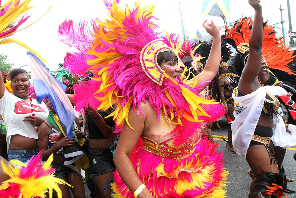 Dressed in costume, Wally Tinsley, foreground, and others make their way along Eastern Parkway in the Brooklyn borough of New York during the West Indian Day Parade.