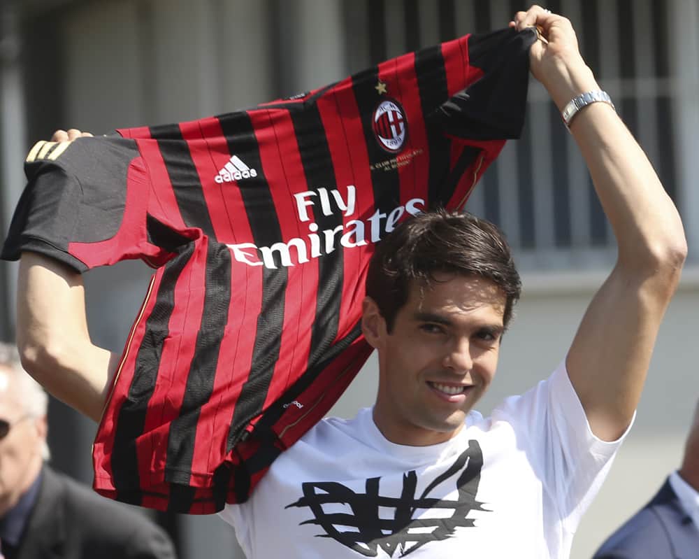 AC Milan player Ricardo Kaka`, of Brazil, holds up the Milan jersey upon his arrival at the Linate airport, in Milan, Italy.