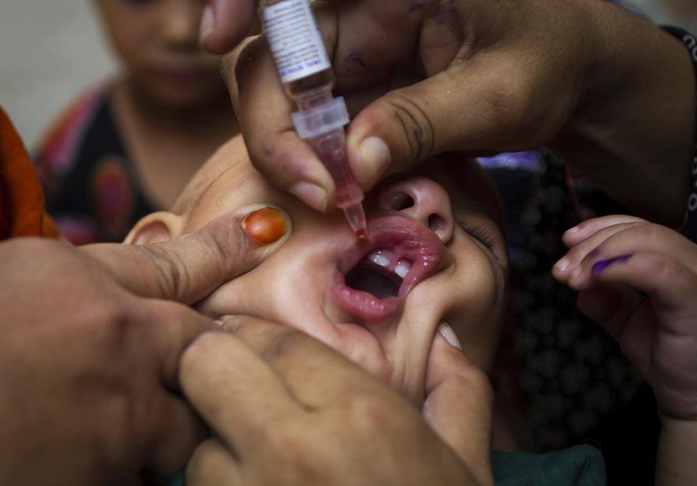 A Pakistani health worker administers vaccine against polio to a child in Rawalpindi, Pakistan.
