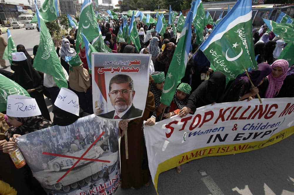 Female supporters of Pakistani religious party Jamaat-i-Islami hold party flags with holy verses meaning
