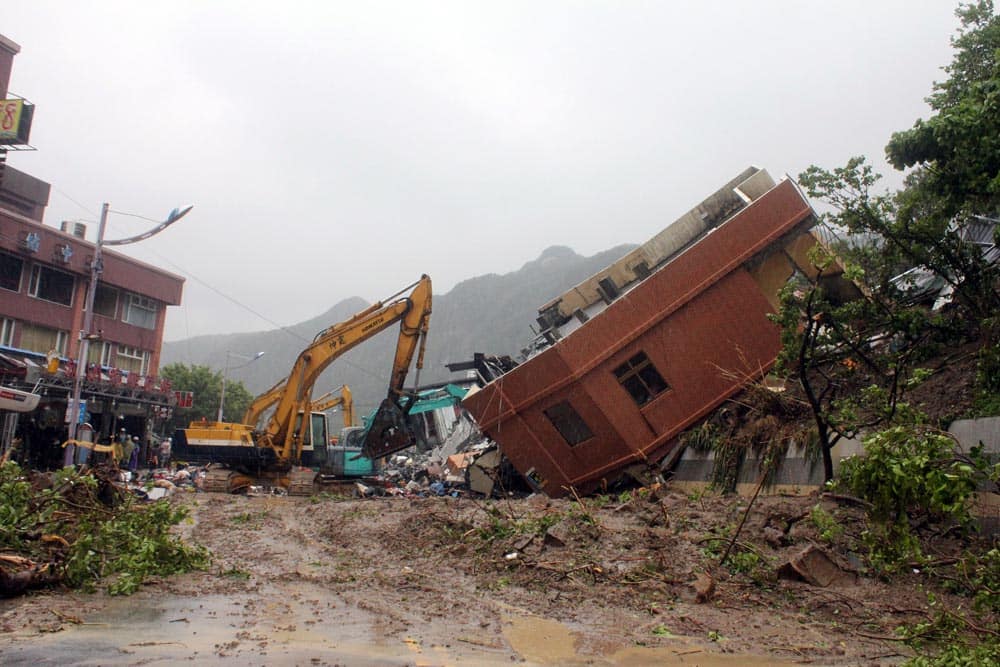 A building is seen toppled on its side from strong flooding caused by heavy rain left from Tropical Storm Kong-Rey in the northeastern town of Keelung, Taiwan.
