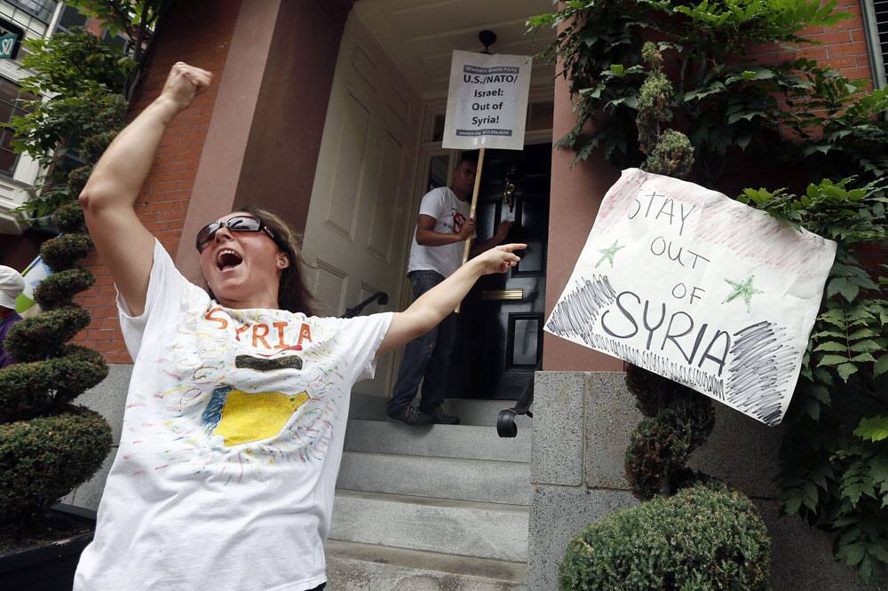 Albira Chamo, of Norwood, Mass., protests against US intervention in Syria outside the house of Secretary of State John Kerry in Boston.