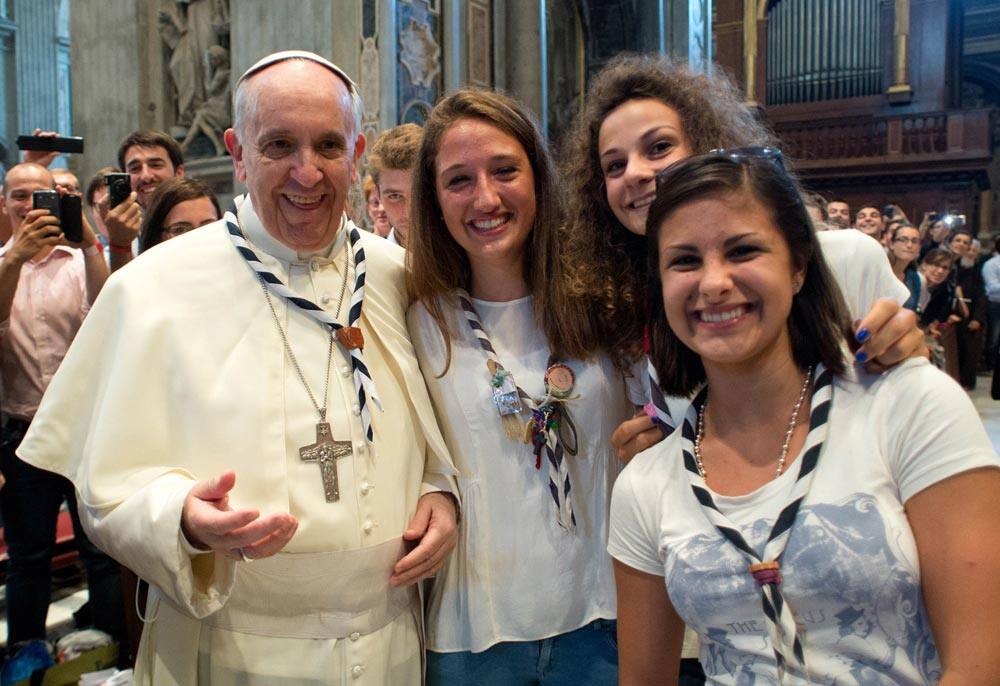 This photo provided by the Vatican newspaper L`Osservatore Romano, Pope Francis has his picture taken inside St. Peter`s Basilica with youths from the Italian Diocese of Piacenza and Bobbio who came to Rome for a pilgrimage, at the Vatican.