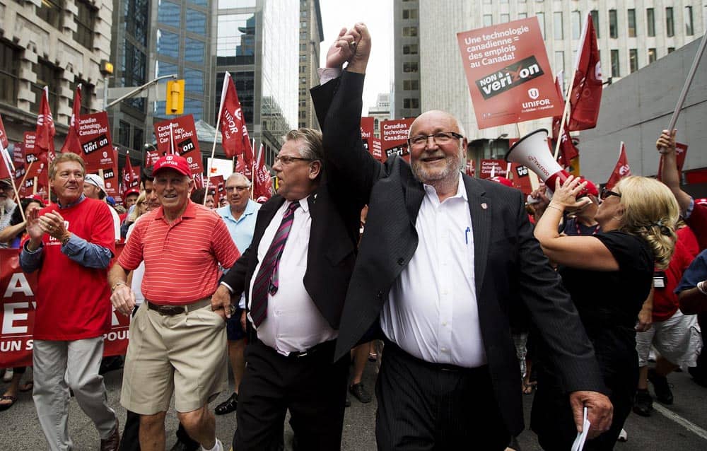 Canadian Auto Workers` president Ken Lewenza, left, and Communications, Energy and Paperworkers Union of Canada president Dave Coles attend a protest against Verizon Wireless coming to Canada during a rally in Toronto.