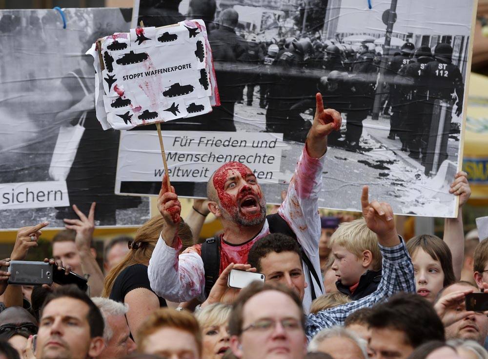 A protestor demonstrates against the export of weapons during an election rally of German Chancellor Angela Merkel in Frankfurt, Germany.