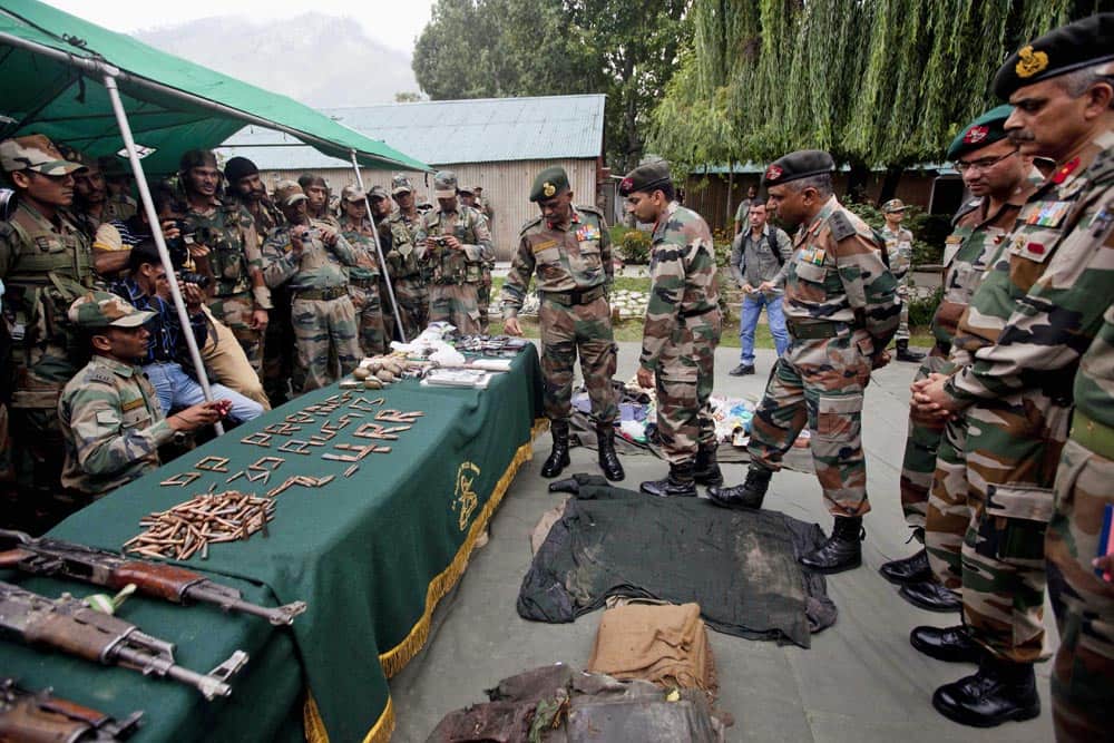 Army officers inspect the arms and ammunition recovered near the bodies of suspected rebels after a gunbattle at an army base in Prang, some 45 kilometers, northeast of Srinagar.