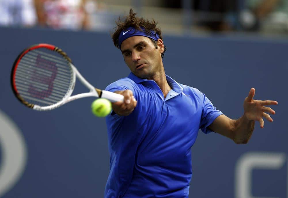 Roger Federer, of Switzerland, returns a shot against Carlos Berlocq, of Argentina, during the second round of the 2013 US Open tennis tournament, in New York.