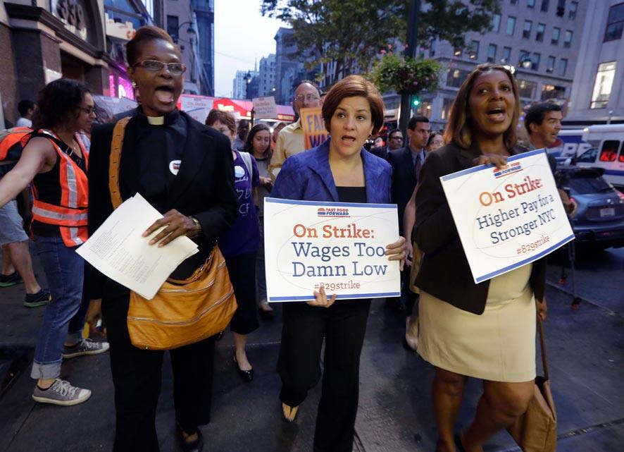 New York City Council Speaker and mayoral candidate Christine Quinn, center, accompanied by Minister Patricia Malcolm, left, and New York City Council member and public advocate candidate Letitia James, lead a fast food workers` protest march on New York`s Fifth Avenue.