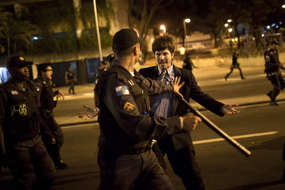 A police officer pushes back a man complaining about the detention of protesters near Guanabara Palace, the office of Rio de Janeiro Governor Sergio Cabral in Rio de Janeiro, Brazil.