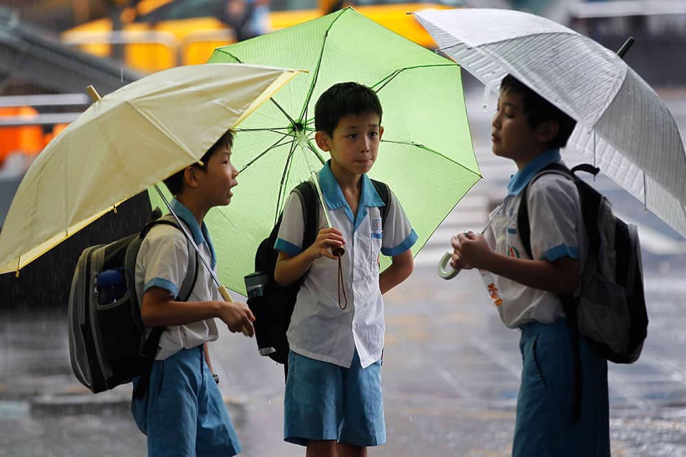 School boys ride out heavy rains from passing Tropical Storm Kong-Rey in Taipei, Taiwan. Tropical Storm Kong-Rey battered Taiwan on Thursday, dumping more than 500 mm (19 inches) of rain on the heavily populated west coast amid widespread flooding.
