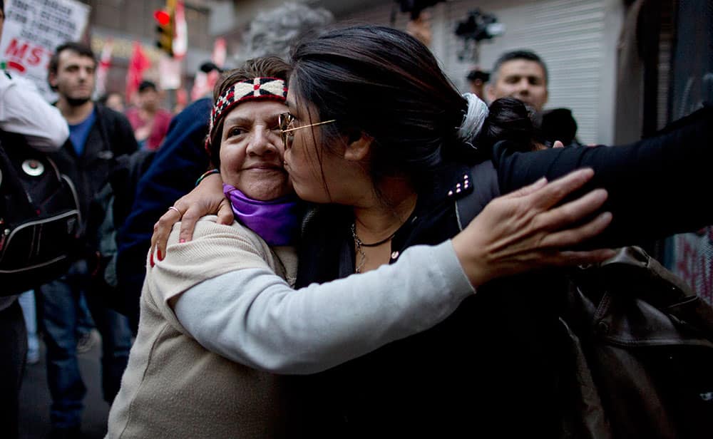 Protestors hug during a demonstration against a possible agreement between YPF and Chevron in Buenos Aires, Argentina.