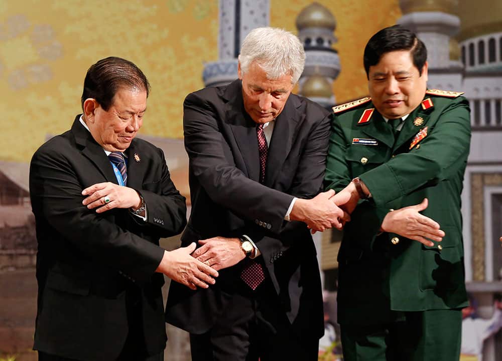 US Defense Secretary Chuck Hagel, center, chains his hands with Vietnam`s Defense Minister Gen. Phung Quang Thanh, right, and Thailand`s Deputy Defense Minister Gen. Yuthasak Sasiprapha before the ASEAN Defense Ministers` Meeting in Bandar Seri Begawan, Brunei.