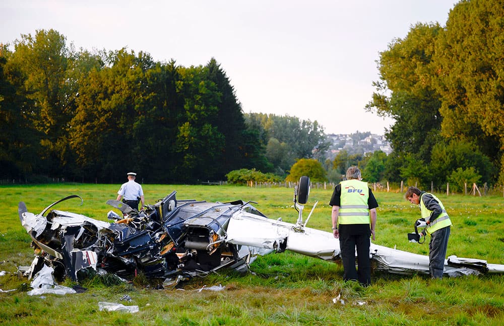 Police officers and firefighters secure the scene of a small plane crash on a field near Froendenberg, north western Germany. Authorities say four adults and one child were killed in the crash and three other children were injured.