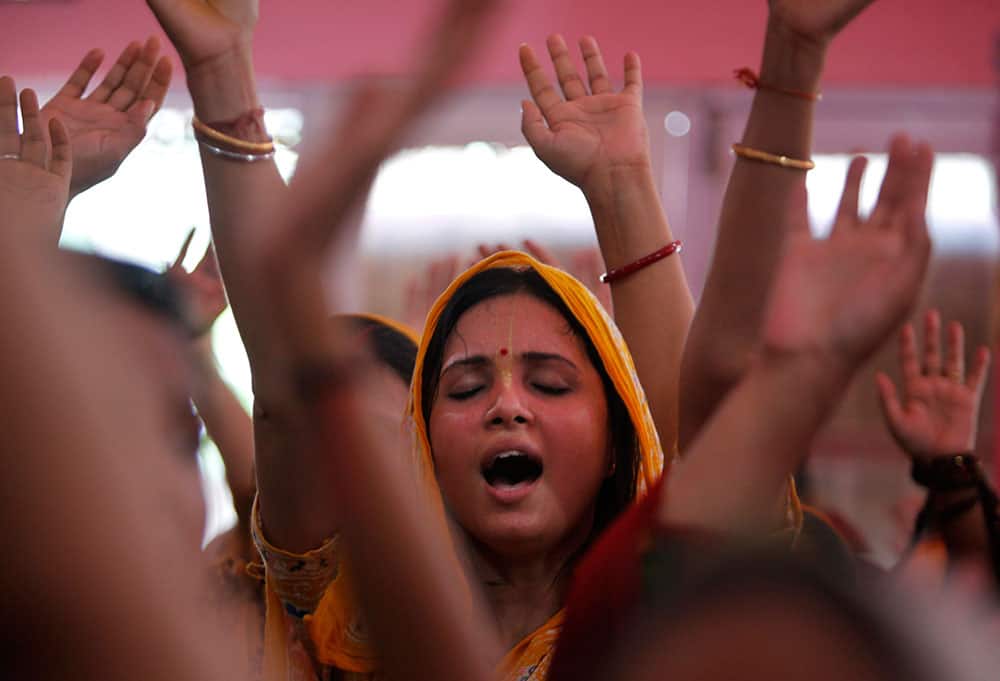Hindu devotees dance as they worship Lord Krishna as part of Janamashtami celebrations at the ISKON temple in Jammu.