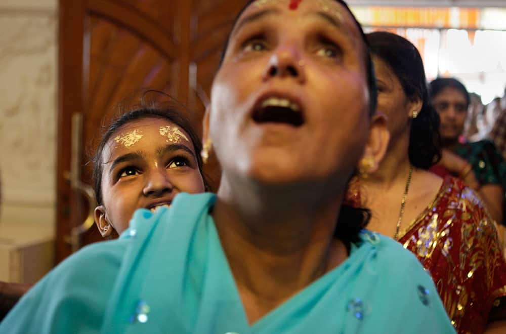 Devotees react as they look at wall paintings at the ISKON temple, a famous Hindu temple of Lord Krishna and Radharani, during Janmashtami in New Delhi.