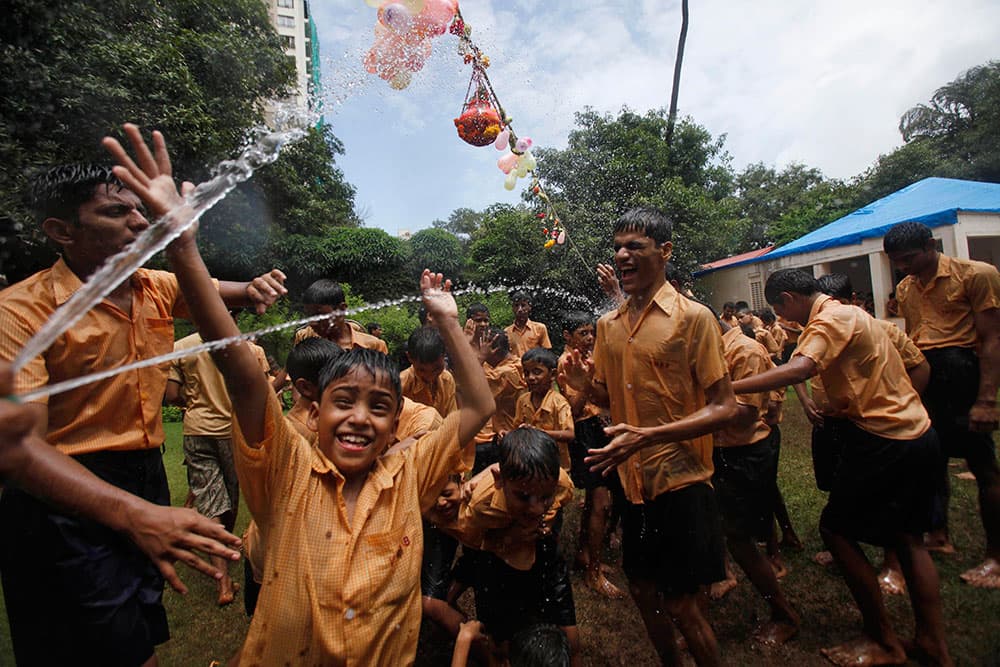 Blind children react as water is sprinkled on them during celebrations to mark ‘Janmashtami’ at the Victoria school for the blind in Mumbai.