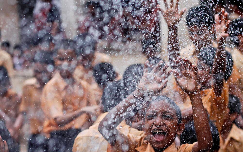 Blind children react as water is sprinkled on them during celebrations to mark ‘Janmashtami’ at the Victoria school for the blind in Mumbai.