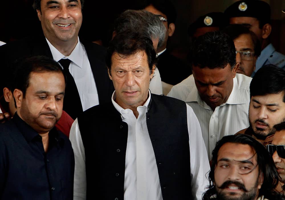 Cricketer-turned-politician and head of Pakistan Tehree-e-Insaf or Moment for Justice Imran Khan, center, leaves the Supreme Court after his case hearing in Islamabad, Pakistan.