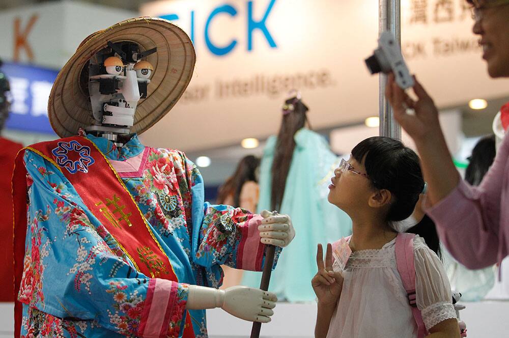 A young visitor watches a robot stir a pot of food during the Taipei International Robot Show in Taipei, Taiwan. The show will run from Aug. 28-31.