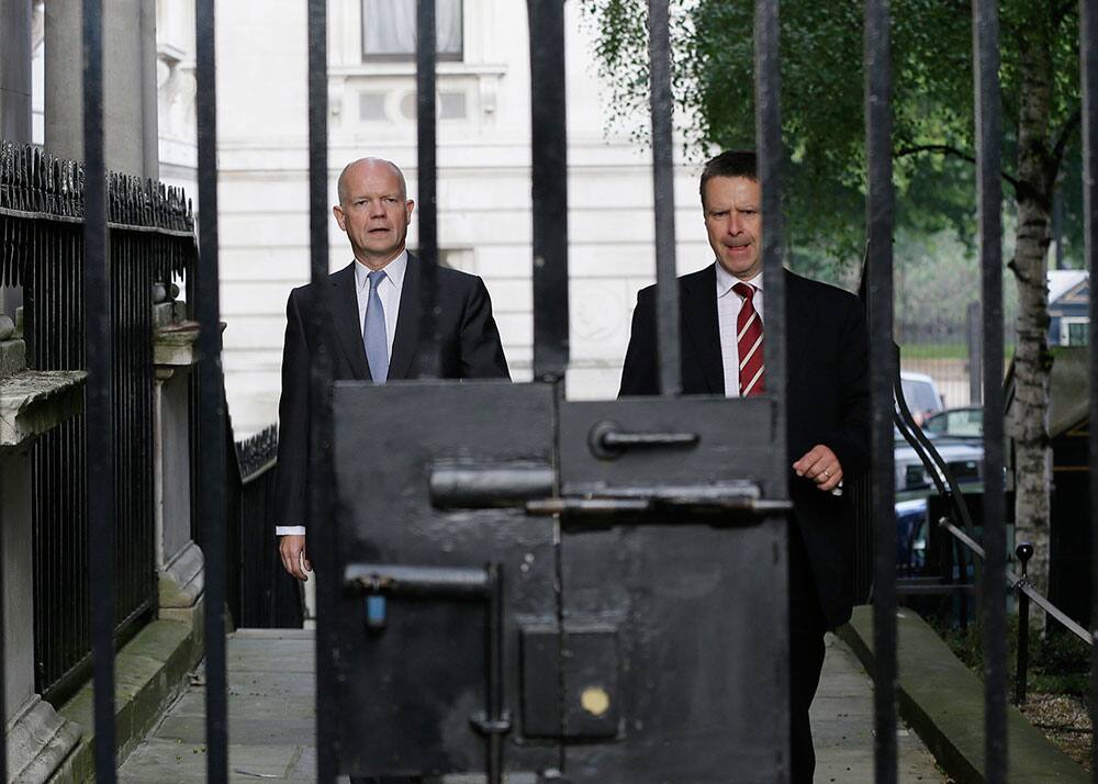 Britain` Foreign Secretary William Hague walks with his security officer to Downing Street ahead of a national security meeting to be held at the Cabinet office with Prime Minister David Cameron on the situation in Syria, in London.