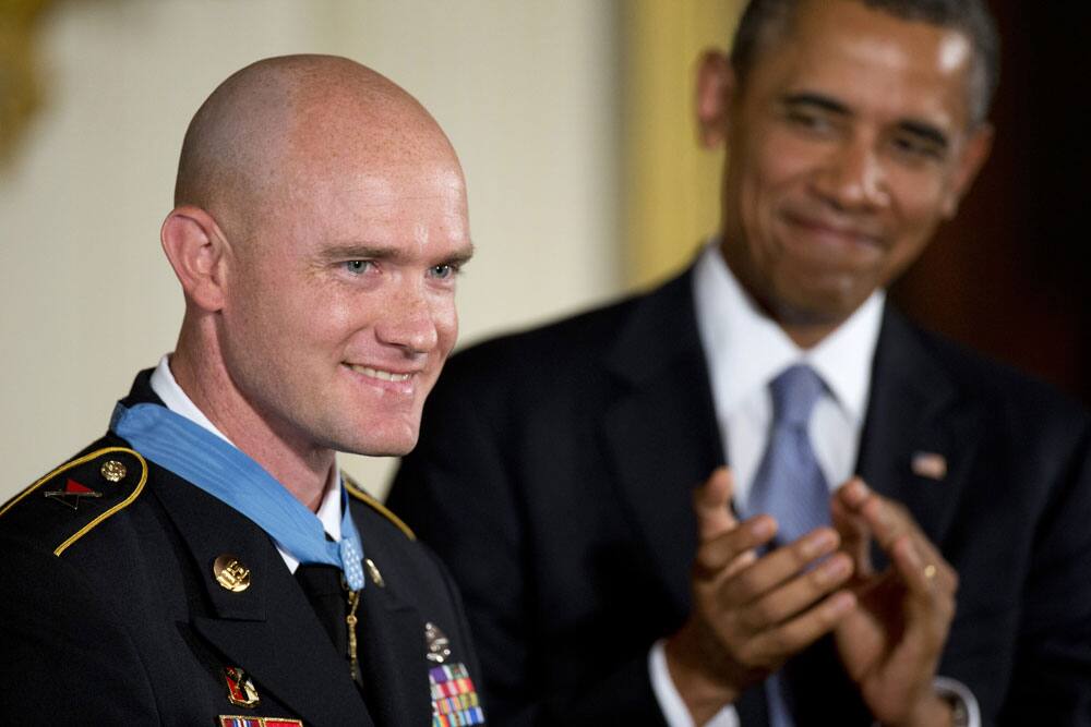 President Barack Obama looks at US Army Staff Sgt. Ty M. Carter and applauds after awarding him the Medal of Honor for conspicuous gallantry, during a ceremony in the East Room of the White House in Washington.
