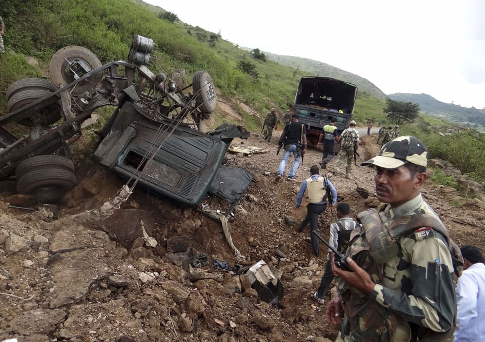 Indian paramilitary soldiers stand near their damaged vehicle after Maoist rebels ambushed their patrol at Koraput district in Odisha state.