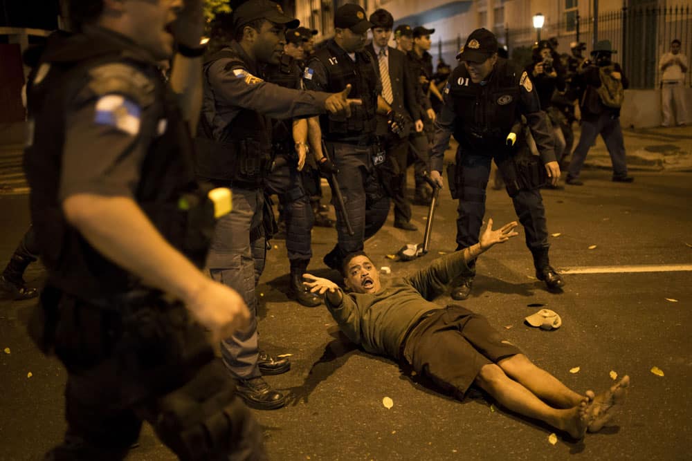 A man complains about being hit by police after falling to the ground during a protest near Guanabara Palace, the office of Rio de Janeiro Governor Sergio Cabral in Rio de Janeiro.