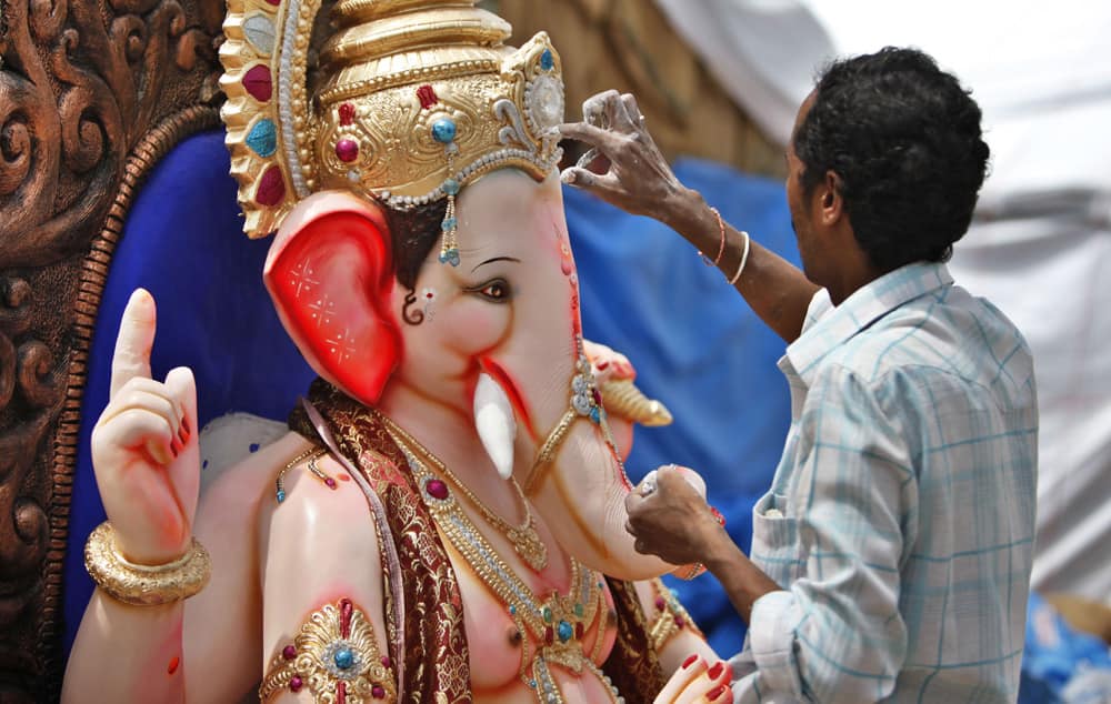 An artisan works on an idol of Hindu god Ganesh ahead of Ganesh Chaturthi festival at a workshop in Bangalore.
