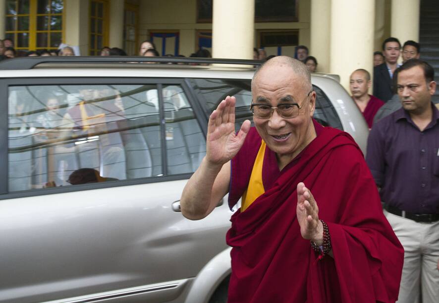 Tibetan spiritual leader the Dalai Lama greets devotees as he leaves after his religious talk at the Tsuglakhang temple in Dharmsala.