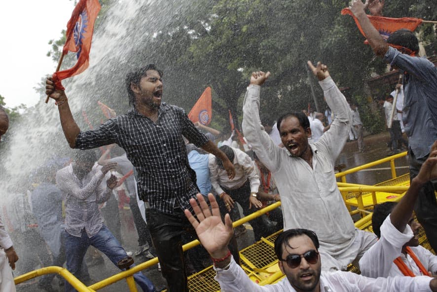 Activists of World Hindu Council or Vishwa Hindu Parishad (VHP) shout as they are hit with a police water cannon during a protest in New Delhi.
