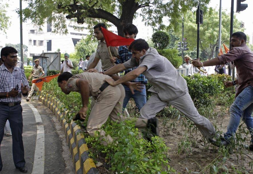 Supporters of World Hindu Council or Vishwa Hindu Parishad (VHP) push a policeman during a protest in New Delhi.