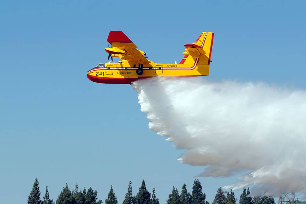 A Canadian Bombardier CL-415 Super Scooper firefighting plane drops water during a demonstration for public officials at Van Nuys Airport in Los Angeles.