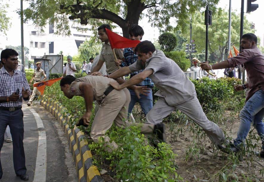 Supporters of World Hindu Council or Vishwa Hindu Parishad (VHP) push a policeman during a protest in New Delhi.